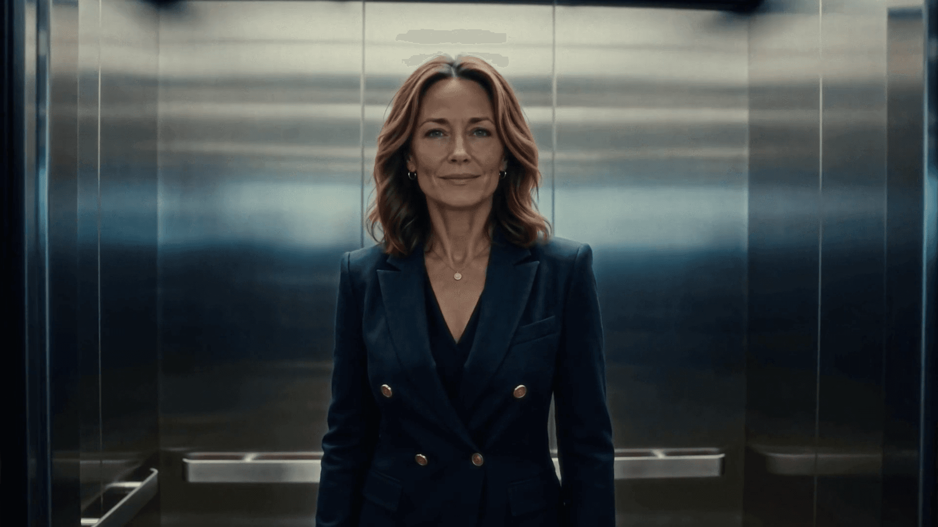 Quin standing in a lift, facing the camera